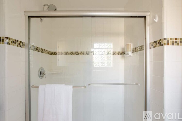 A white towel is hanging on a chrome towel rack.