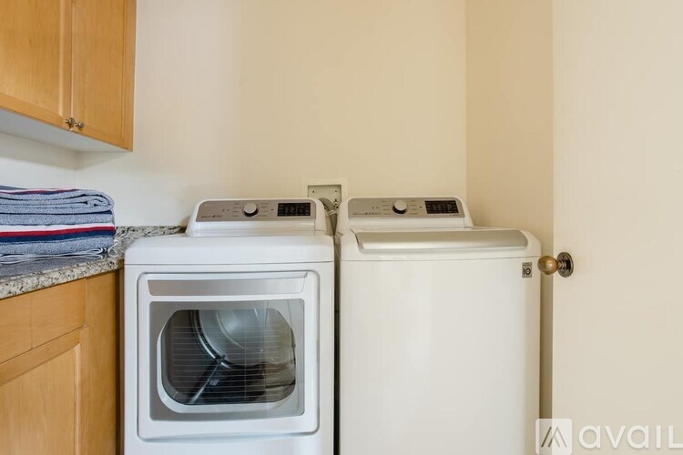 A white microwave oven is placed next to a white dishwasher in a kitchen.
