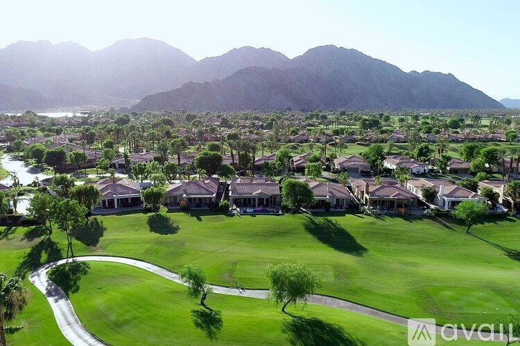 A golf course with houses and mountains in the background.