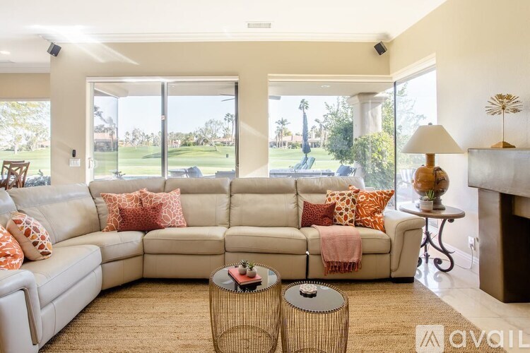 A living room with a large sectional sofa and a fireplace.