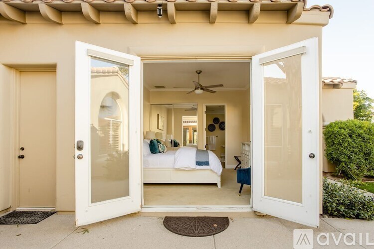 A house with a white door is open to a living room.