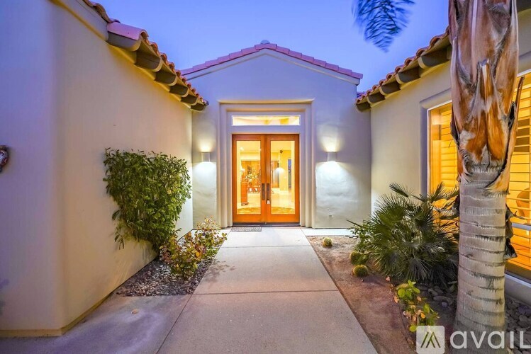 A house entrance with a brown door and a wall on the left.