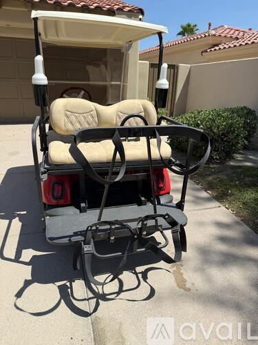 A black and white golf cart is parked on a sidewalk.