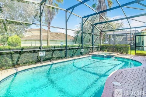 A pool enclosed by a fence with trees in the background.