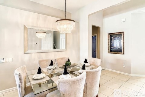 A modern dining room with a glass table and chairs.
