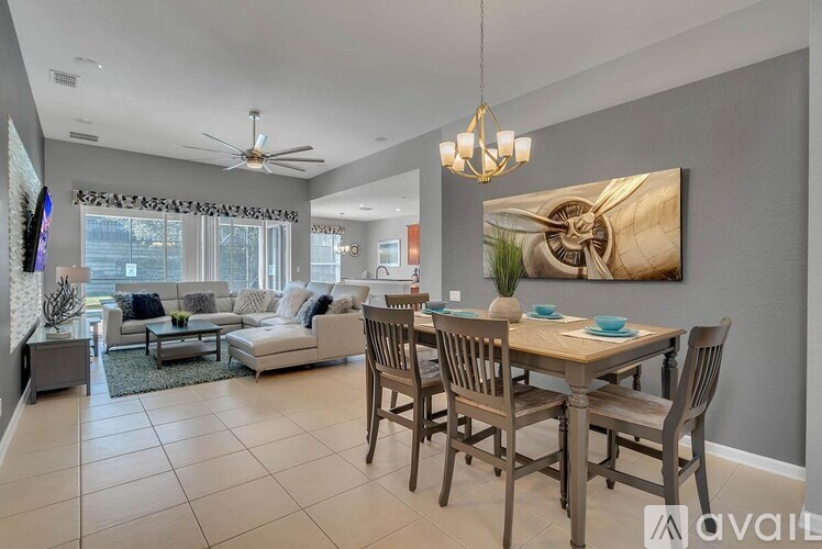 A living room with a dining table set up with chairs.