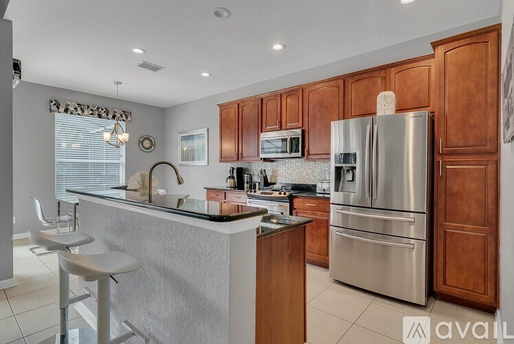 A kitchen with wooden cabinets and a stainless steel refrigerator.