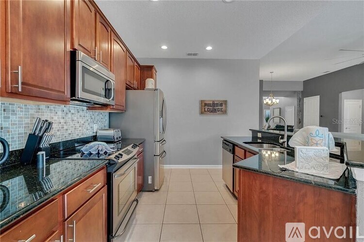 A kitchen with wooden cabinets and a black countertop.