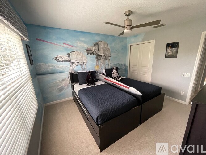 A room with a bed and a wall mural of a space scene.