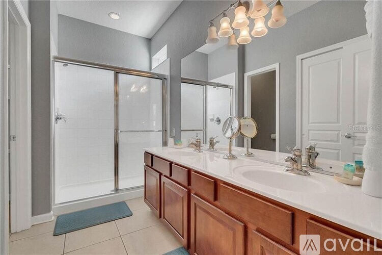 A bathroom with a walk-in shower and double sinks.