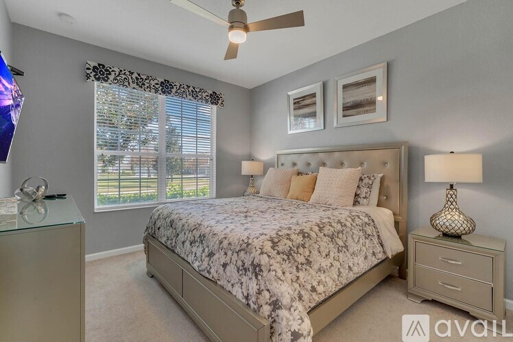 A bedroom with a large bed and a ceiling fan.