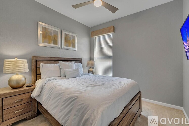 A bedroom with a bed, nightstand, and two pictures on the wall.