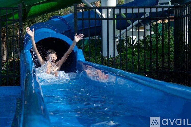 A person sliding down a blue water slide.