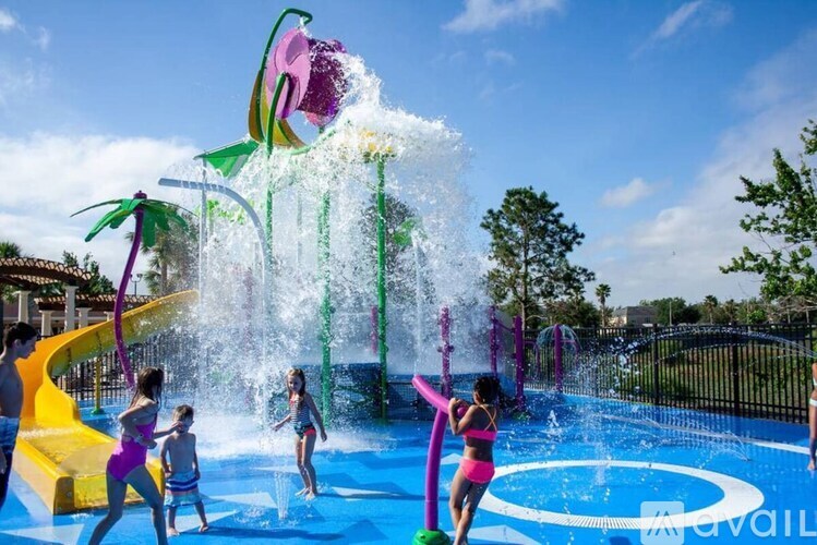 People playing in a water park with a large waterfall and slide.