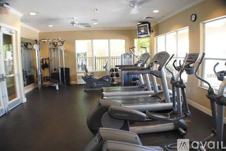 A gym with treadmills, elliptical machines, and other exercise equipment.