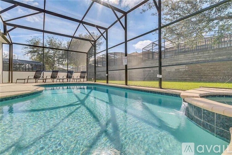 A pool inside a glass enclosure with sunlight shining through.