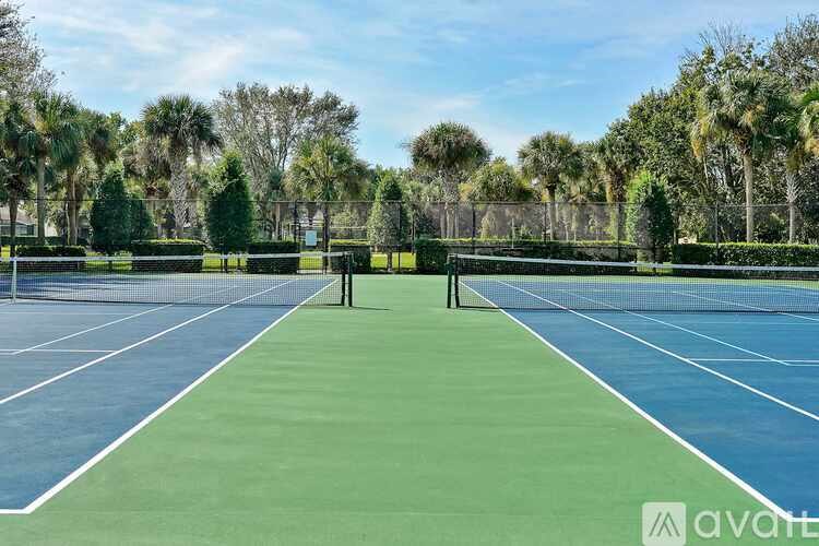A tennis court surrounded by trees and bushes.
