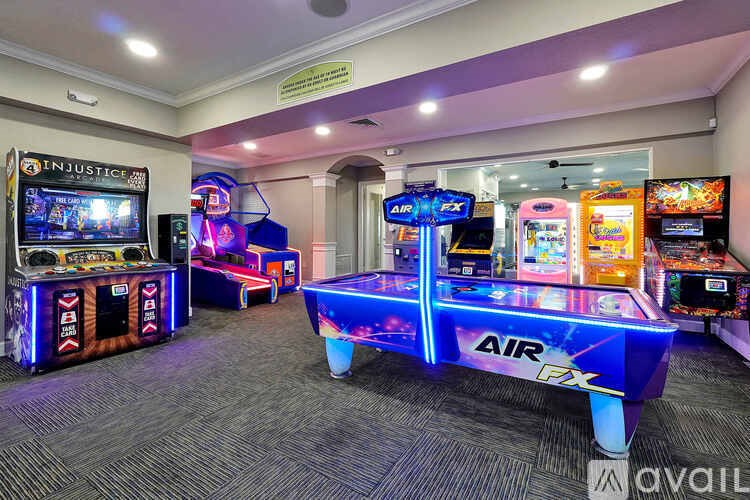 A room with a carpeted floor and a row of arcade games.