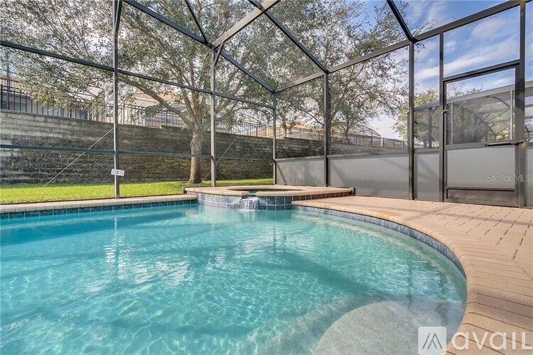 A pool with a glass enclosure and a deck.