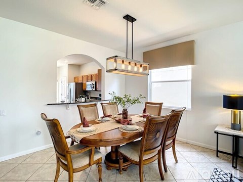 A dining room with a table set for four.
