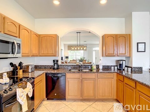A kitchen with wooden cabinets and a black dishwasher.