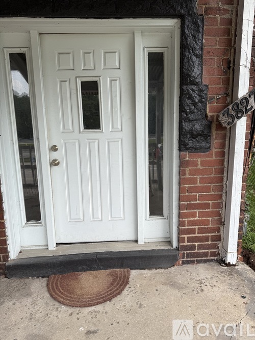 A white door with a glass panel and a doormat in front of it.