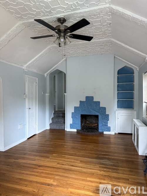 A room with a fireplace and a ceiling fan.