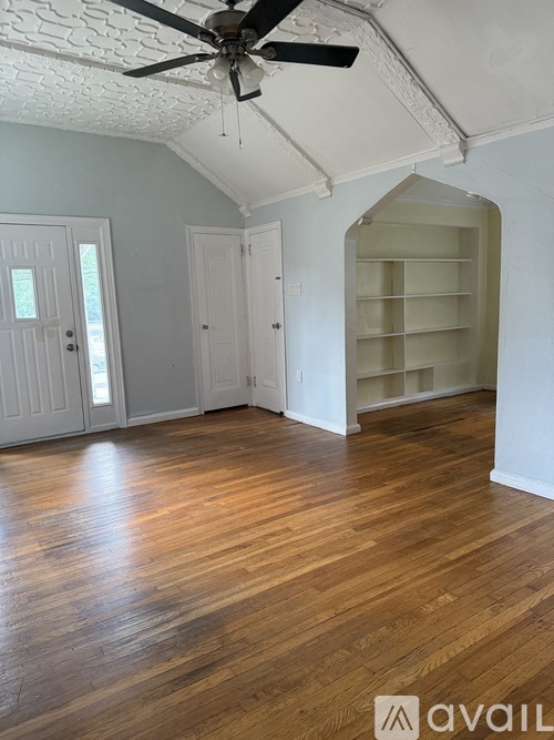 A room with wooden floors and a ceiling fan.