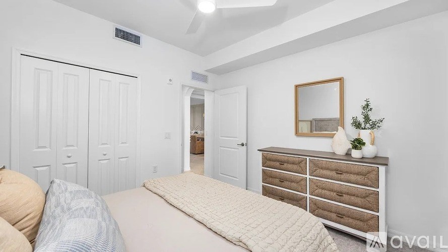 A bedroom with a bed, dresser, and mirror.