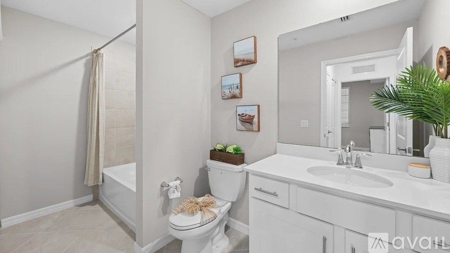 A white bathroom with a toilet, sink, and mirror.