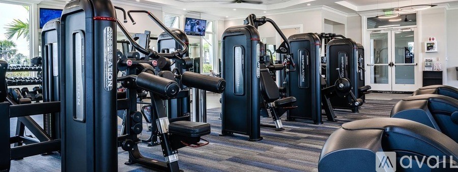 A gym with a variety of equipment including treadmills, weights, and exercise machines.