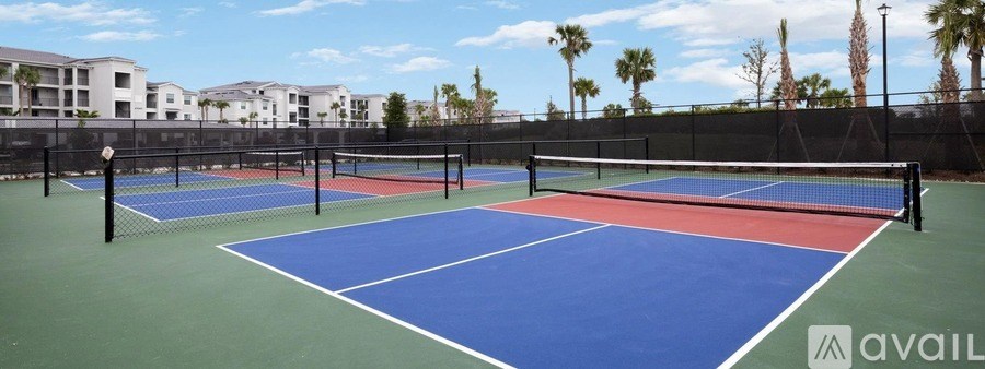 Tennis courts with a blue and red surface and black fencing.