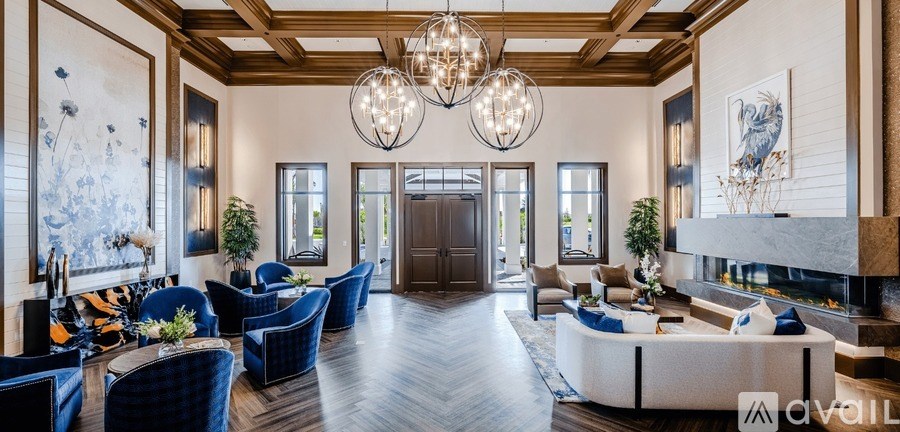 A spacious living room with a high ceiling and a chandelier.