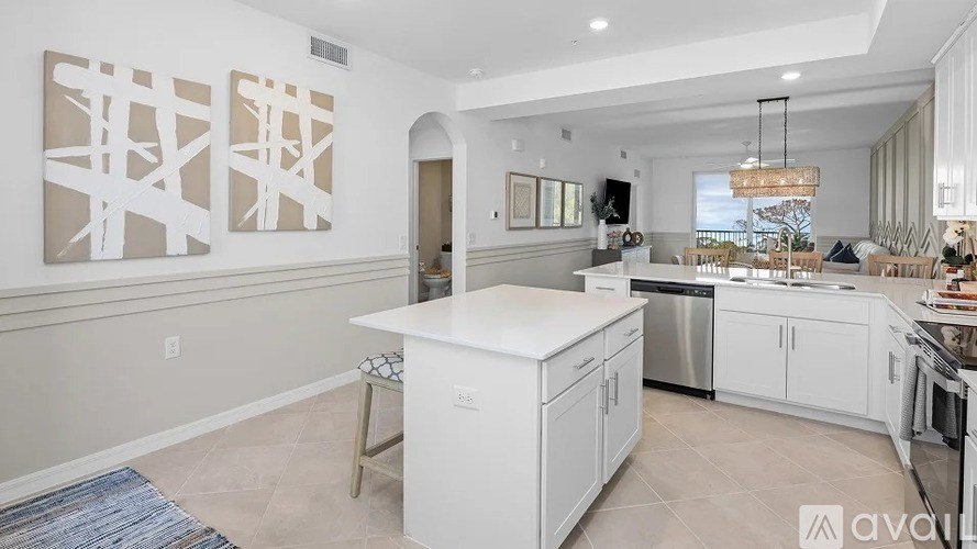 A kitchen with white cabinets and a large island.