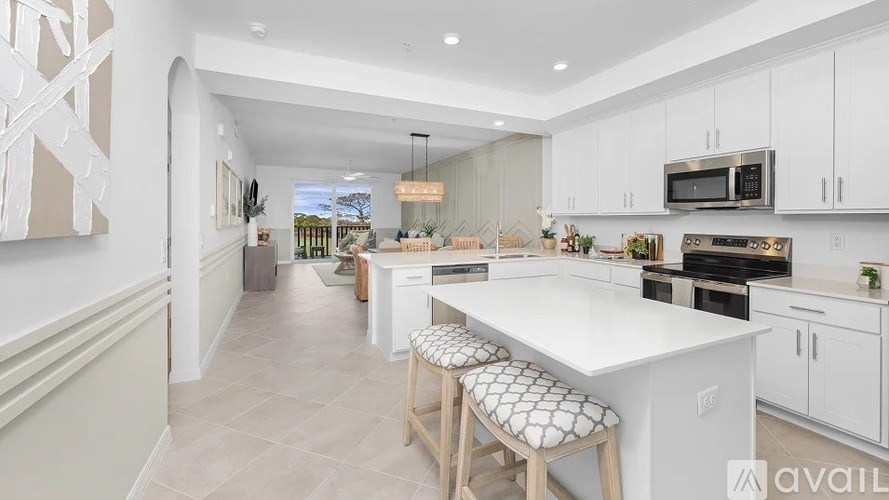 A modern kitchen with white cabinets and a large island.