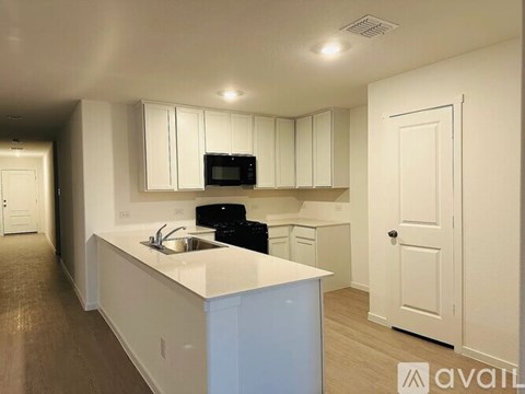 A kitchen with white cabinets and a blue island.
