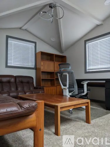 A living room with a brown leather couch and a wooden coffee table.