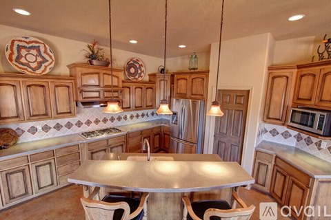 A kitchen with wooden cabinets and a large island in the center.