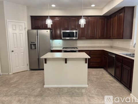 A kitchen with brown cabinets and a white island.