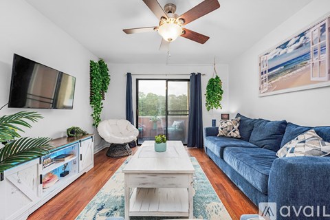A living room with a blue couch and a white coffee table.