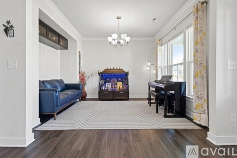 A living room with a blue sofa and a piano.