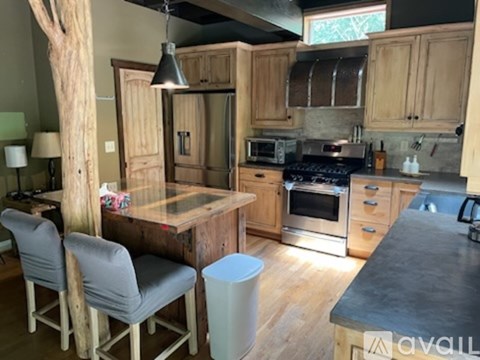 A kitchen with wooden cabinets and a black countertop.