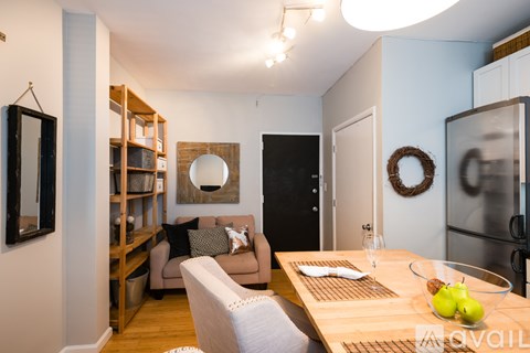 A modern kitchen with a dining table set with a white napkin and two green apples.
