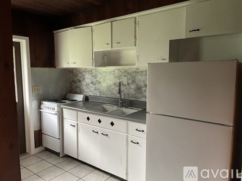A kitchen with white cabinets and appliances.