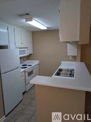 A kitchen with white appliances and a white counter.