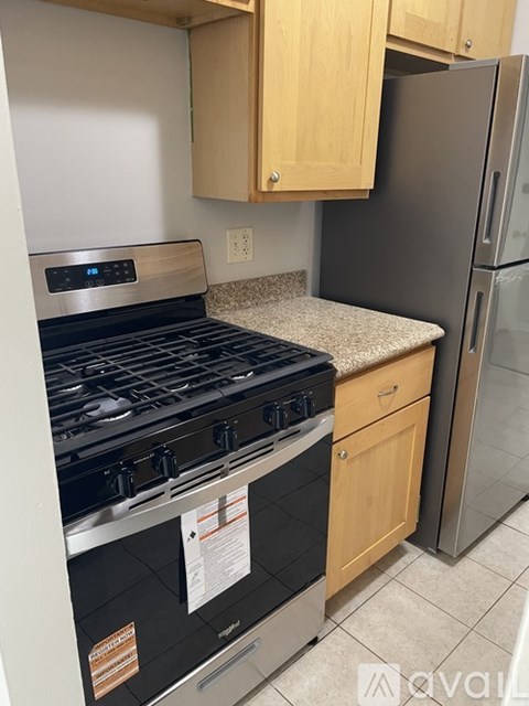 A kitchen with a stove top oven and a refrigerator.