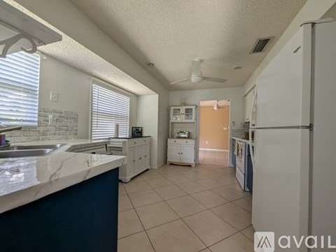 A kitchen with a blue counter and white appliances.