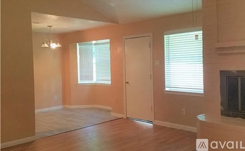 A room with a wooden floor and a television on the wall.