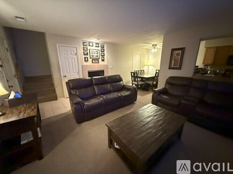 A living room with a couch, chairs, and a coffee table.