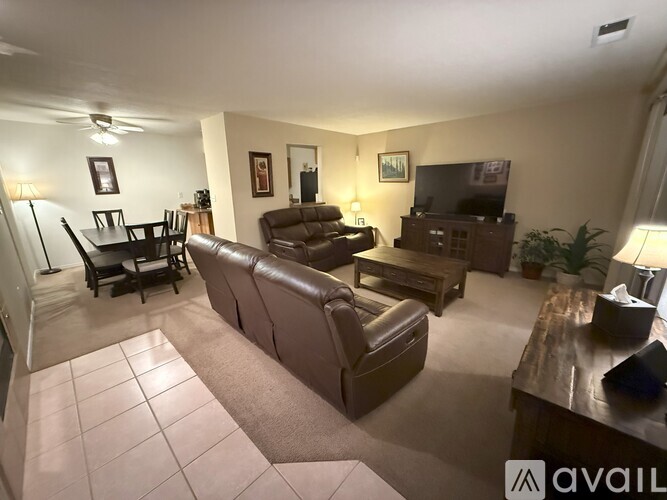 A living room with a couch, chair, and television.